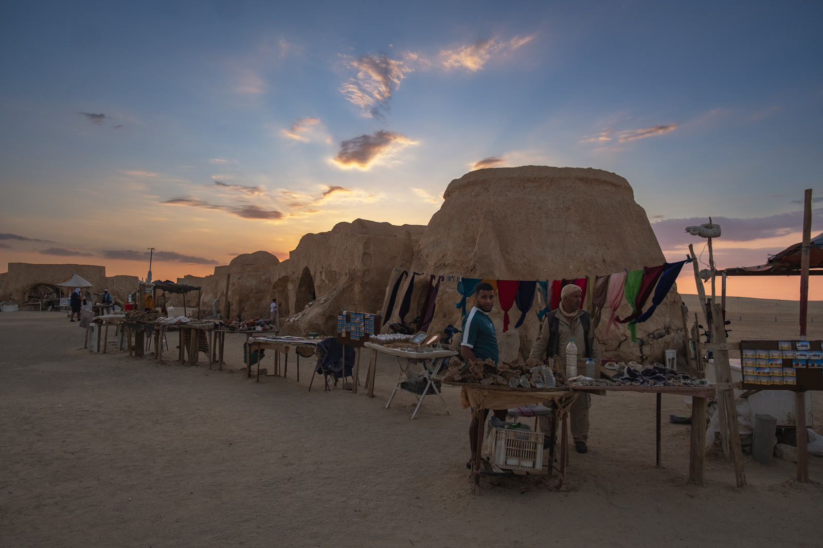 Goods hung out in a mud-brick courtyard at sunset
